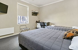 a queen-size bed and a single bed in executive queen studio